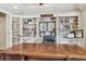 Office with a large wooden desk, built-in shelving with pictures, and a large leather office chair at 3149 Hidden Falls Ne Dr, Buford, GA 30519