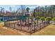 Outdoor fenced playground area with climbing equipment and slides next to community tennis courts and common grounds at 3149 Hidden Falls Ne Dr, Buford, GA 30519