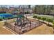 Community playground with slides, climbing structure, and a secure fenced area next to tennis courts and a clubhouse at 3149 Hidden Falls Ne Dr, Buford, GA 30519