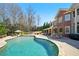 An expansive backyard pool and patio sit beside a brick house with many windows at 3149 Hidden Falls Ne Dr, Buford, GA 30519