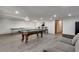Finished basement boasts a pool table, ping pong table, gray floors, and a gray couch at 2970 Oxford Rd, Atlanta, GA 30349