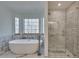 Modern bathroom showcasing soaking tub next to windows and a glass enclosed shower with subway tile surround at 2970 Oxford Rd, Atlanta, GA 30349