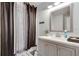 This bathroom features a shower with curtain, a large mirror, and a light gray vanity at 2970 Oxford Rd, Atlanta, GA 30349