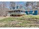 Blue home with a long porch and manicured lawn surrounded by a beautiful forest at 2970 Oxford Rd, Atlanta, GA 30349