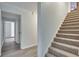 Hallway with staircase features access to multiple rooms with neutral paint and gray floors and carpets at 2970 Oxford Rd, Atlanta, GA 30349