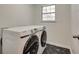Well-lit laundry room with sleek washer and dryer set, complemented by stylish geometric flooring at 2970 Oxford Rd, Atlanta, GA 30349