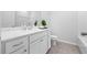 Bright bathroom featuring a white vanity, framed mirror, white toilet, and gray tile flooring at 2121 Hempstead Ct, Snellville, GA 30078