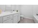 Modern bathroom with a white vanity, framed mirror, white toilet, and gray tile flooring at 2121 Hempstead Ct, Snellville, GA 30078
