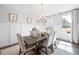 Bright dining room featuring wainscoting, a modern chandelier, and a large window overlooking the neighborhood at 2121 Hempstead Ct, Snellville, GA 30078