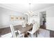 Elegant dining room featuring wainscoting, a modern chandelier, and a stylish area rug at 2121 Hempstead Ct, Snellville, GA 30078