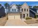 Charming two-story brick home with a two-car garage and manicured front yard under a sunny sky at 2121 Hempstead Ct, Snellville, GA 30078