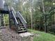Exterior view of the wooden stairs leading to a deck surrounded by a wooded area at 3013 Rockview Dr, Loganville, GA 30052