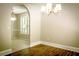 Neutral dining room featuring a chandelier, hardwood floors, arched doorway, and window with natural light at 3013 Rockview Dr, Loganville, GA 30052