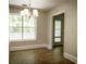 Bright dining room featuring hardwood floors, a modern chandelier, and a large window with a view of lush greenery at 3013 Rockview Dr, Loganville, GA 30052