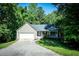 Charming home with a one-car garage and a stone-accented front porch nestled among mature trees at 3013 Rockview Dr, Loganville, GA 30052