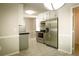 Modern kitchen with stainless steel appliances, black counters, and white cabinets and access to the laundry room at 3013 Rockview Dr, Loganville, GA 30052