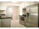 Kitchen featuring stainless steel appliances, black counters, and white cabinets with tiled backsplash at 3013 Rockview Dr, Loganville, GA 30052