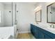Bathroom featuring double vanity, quartz countertops, and tiled walk-in shower at 630 Silva St, Cumming, GA 30040
