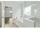 A bright bathroom features a glass shower, soaking tub and tile floors at 630 Silva St, Cumming, GA 30040