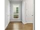 Hallway with light hardwood flooring, white walls, and trim leading to other rooms at 630 Silva St, Cumming, GA 30040