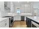 Bright kitchen with stainless steel appliances, white cabinets, tile backsplash and hardwood floors at 630 Silva St, Cumming, GA 30040