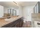 Primary bathroom with double vanity, granite countertops, decorative dark cabinets, walk-in shower, and soaking tub at 1831 Broad River Rd, Atlanta, GA 30349