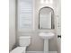 Well-lit half bathroom features a pedestal sink, modern fixtures, and a decorative mirror at 2517 Ashwicke Se Dr, Atlanta, GA 30339