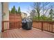 View of the home's wooden deck with wood railing and a barbecue grill with dark cover at 2517 Ashwicke Se Dr, Atlanta, GA 30339
