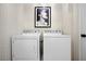 Laundry room with patterned wallpaper, and modern front-loading washer and dryer at 2517 Ashwicke Se Dr, Atlanta, GA 30339