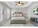 Well-lit main bedroom with a tray ceiling, plush carpet, a large bed, and a modern dresser at 2517 Ashwicke Se Dr, Atlanta, GA 30339