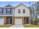 Two-story townhome boasts brick accents, single car garage, and neutral color palette at 7005 Livia Pt, Riverdale, GA 30296
