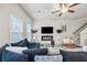 Bright living room with modern fireplace, ceiling fan, and plush furniture at 7005 Livia Pt, Riverdale, GA 30296