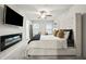 Main bedroom with decorative fireplace, ceiling fan, and plush king bed at 7005 Livia Pt, Riverdale, GA 30296
