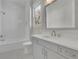 Bright bathroom with white vanity, bathtub with shower and a large mirror above the sink at 123 Candler Loop, Acworth, GA 30101