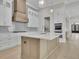 Bright kitchen features a large island, custom range hood, white cabinets, and modern lighting at 123 Candler Loop, Acworth, GA 30101