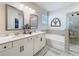 Bright bathroom with double vanity, soaking tub, and glass-enclosed shower at 142 Richmond Way, Villa Rica, GA 30180