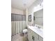Well-lit bathroom features a shower with decorative curtain, single sink vanity, and modern fixtures at 142 Richmond Way, Villa Rica, GA 30180