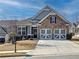 Charming home featuring a stone facade, two-car garage, and well-maintained landscaping at 142 Richmond Way, Villa Rica, GA 30180