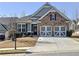 Charming home with stone accents, a two-car garage, and a well-manicured lawn at 142 Richmond Way, Villa Rica, GA 30180