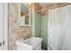 Classic bathroom with vintage pink wallpaper, mint green tiles, and a modern sink fixture at 1566 Arden Sw Dr, Marietta, GA 30008