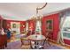 Red dining room with hardwood floors, a chandelier, and neutral curtains at 1566 Arden Sw Dr, Marietta, GA 30008