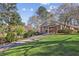 Charming brick home with lush green lawn and mature trees, featuring a long driveway and cozy front entrance at 1566 Arden Sw Dr, Marietta, GA 30008