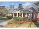 Charming brick home with a manicured lawn and inviting front porch at 1566 Arden Sw Dr, Marietta, GA 30008