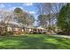 Beautifully landscaped front yard of a brick home with mature trees at 1566 Arden Sw Dr, Marietta, GA 30008