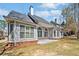 Back exterior featuring gray siding, arched windows and a brick foundation with green grass at 2121 Whitekirk Nw St, Kennesaw, GA 30152