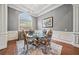 Formal dining room with tray ceiling, wainscoting, large windows, and seating for four at 2121 Whitekirk Nw St, Kennesaw, GA 30152