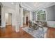 Refined dining area featuring detailed columns, hardwood floors, and natural light from the large window at 2121 Whitekirk Nw St, Kennesaw, GA 30152