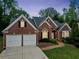 Charming brick home with a two-car garage, manicured lawn, and inviting walkway at 2121 Whitekirk Nw St, Kennesaw, GA 30152