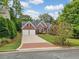 Charming brick home featuring a manicured lawn, lush landscaping, and a two car garage at 2121 Whitekirk Nw St, Kennesaw, GA 30152