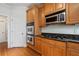 Modern kitchen with stainless steel oven, microwave, range, granite countertops, and wooden cabinets at 2121 Whitekirk Nw St, Kennesaw, GA 30152